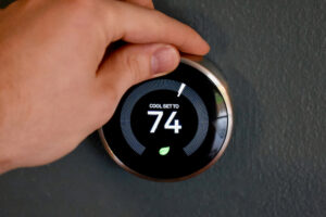 Hand Adjusting Thermostat to 74 Degrees - K-Guard St. Louis