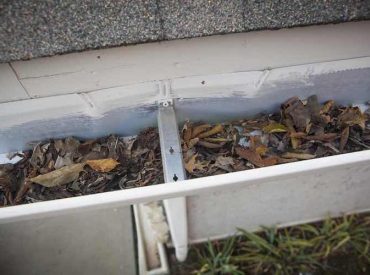 Clogged White Gutter with Leaves and Debris - K-Guard St. Louis